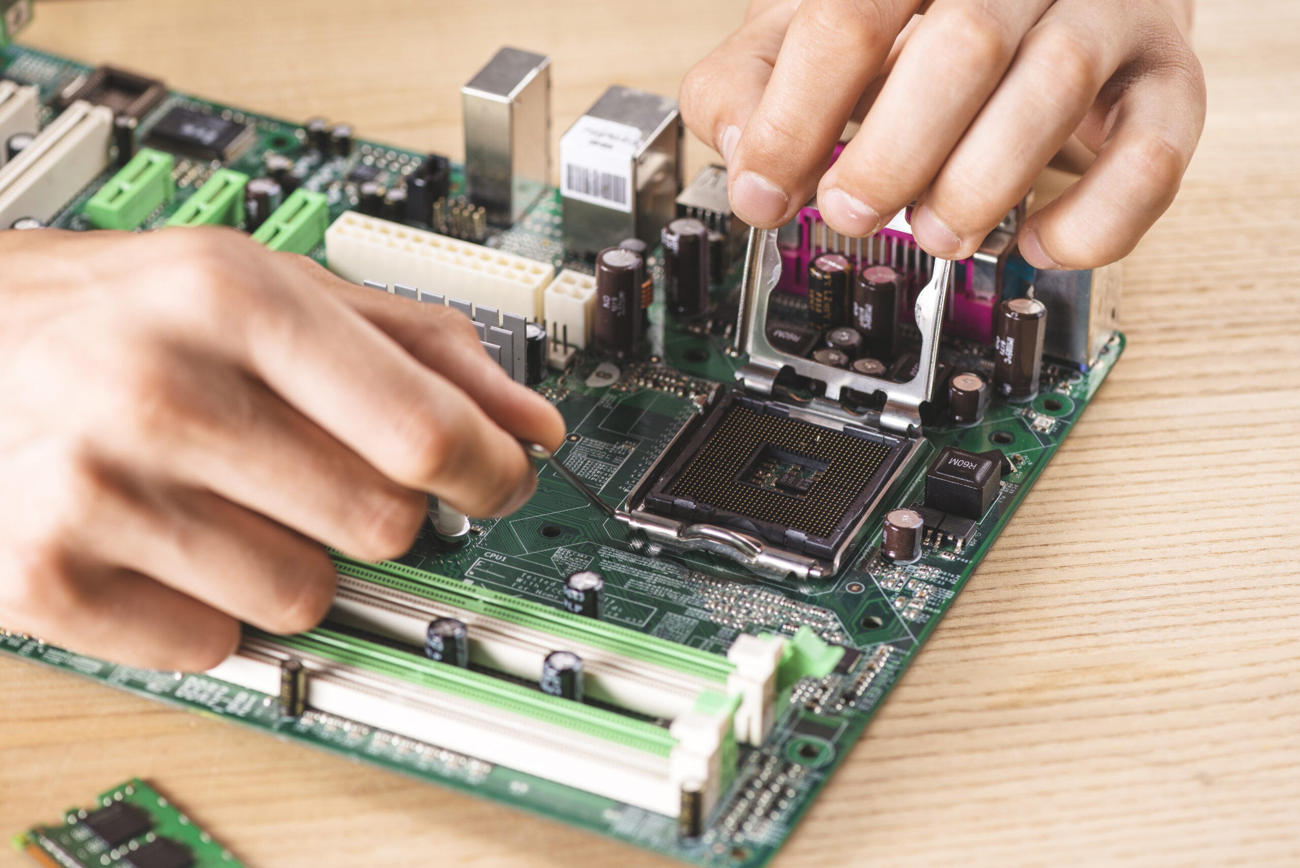 close-up-male-technician-repairing-cpu-socket-wooden-table